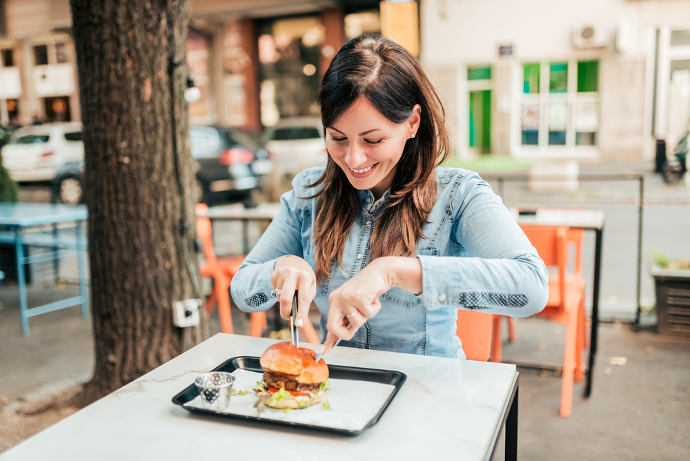 Djevojka jede burger u restoranu