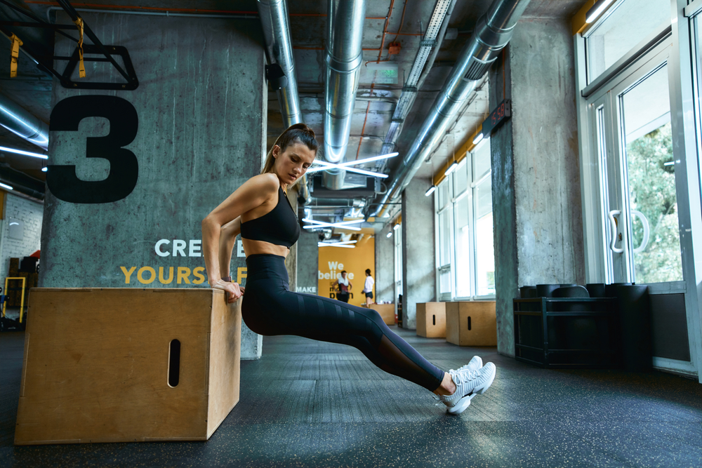 Trening žene u gymu - triceps vježba