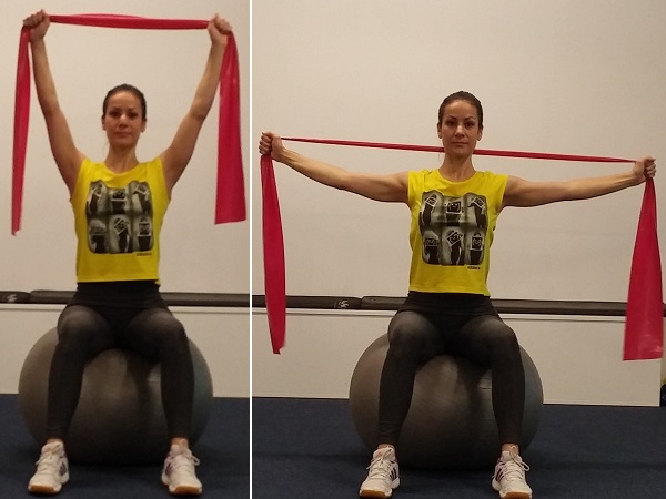 Razvlačenje elastične trake sjedom na pilates lopti